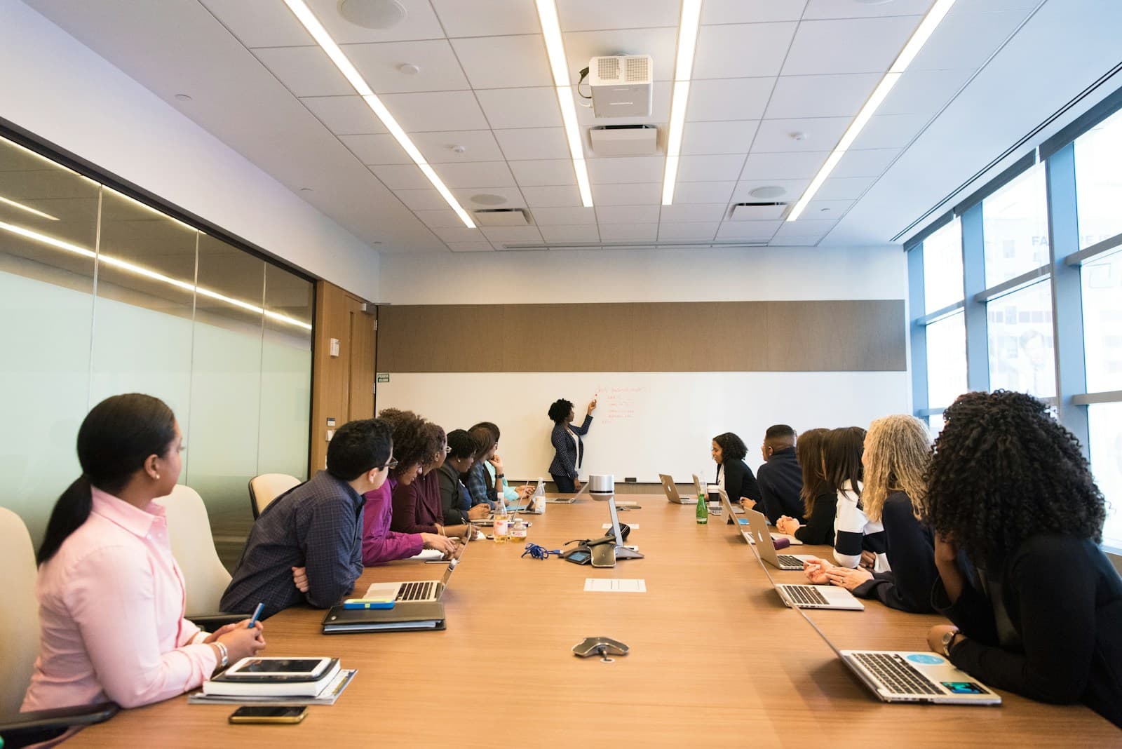 A diverse team in a boardroom meeting while a colleague presents next steps